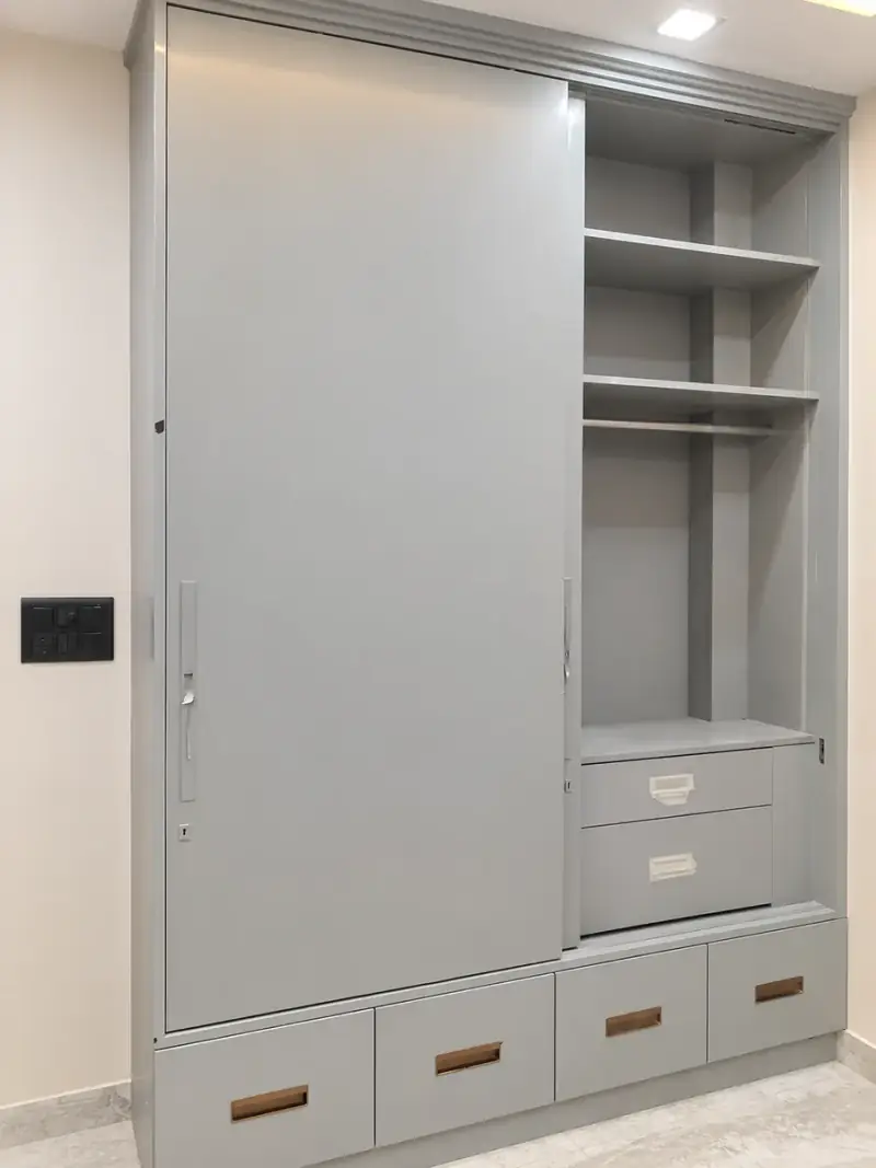 Built-in grey wardrobe with a sliding door, open shelving and a drawer run